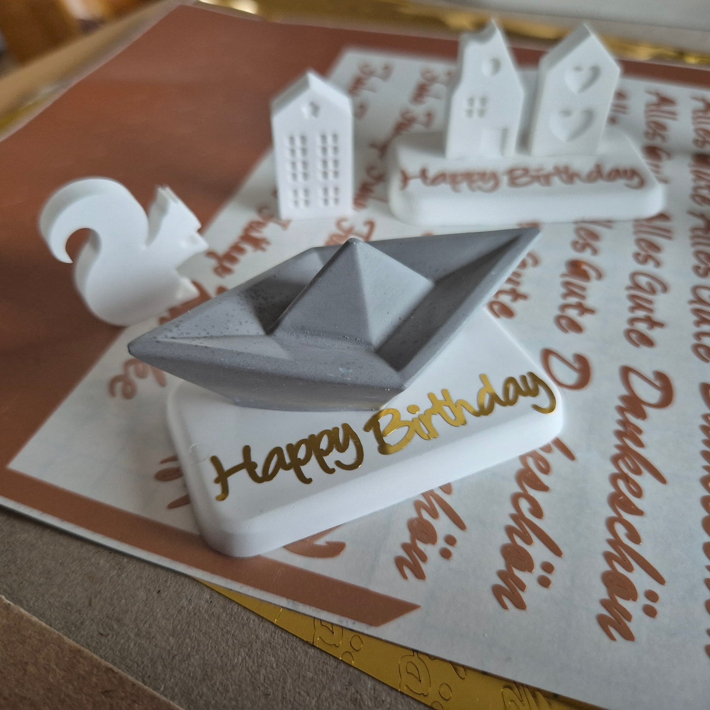 Kleine Geschenke aus Gießbeton auf einem Sockel mit Grußtext, ca. 7,0 x 4,5 cm